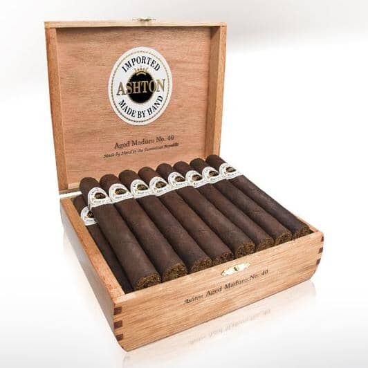 Open box of Ashton Aged Maduro premium cigars showing the rich, dark brown cigars with smooth wrappers and visible cigars in the box.